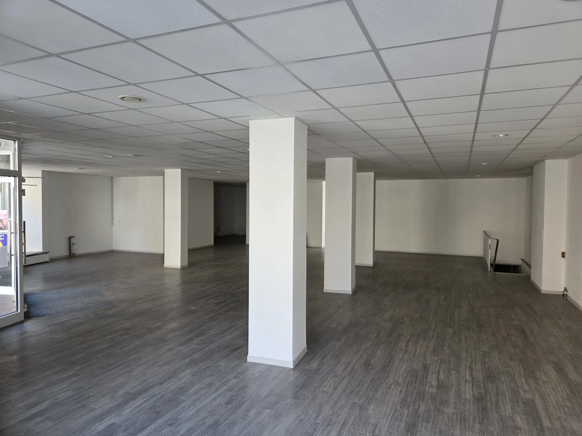 Offene Hauptfläche mit weißen Stützen und Blick zum Schaufenster